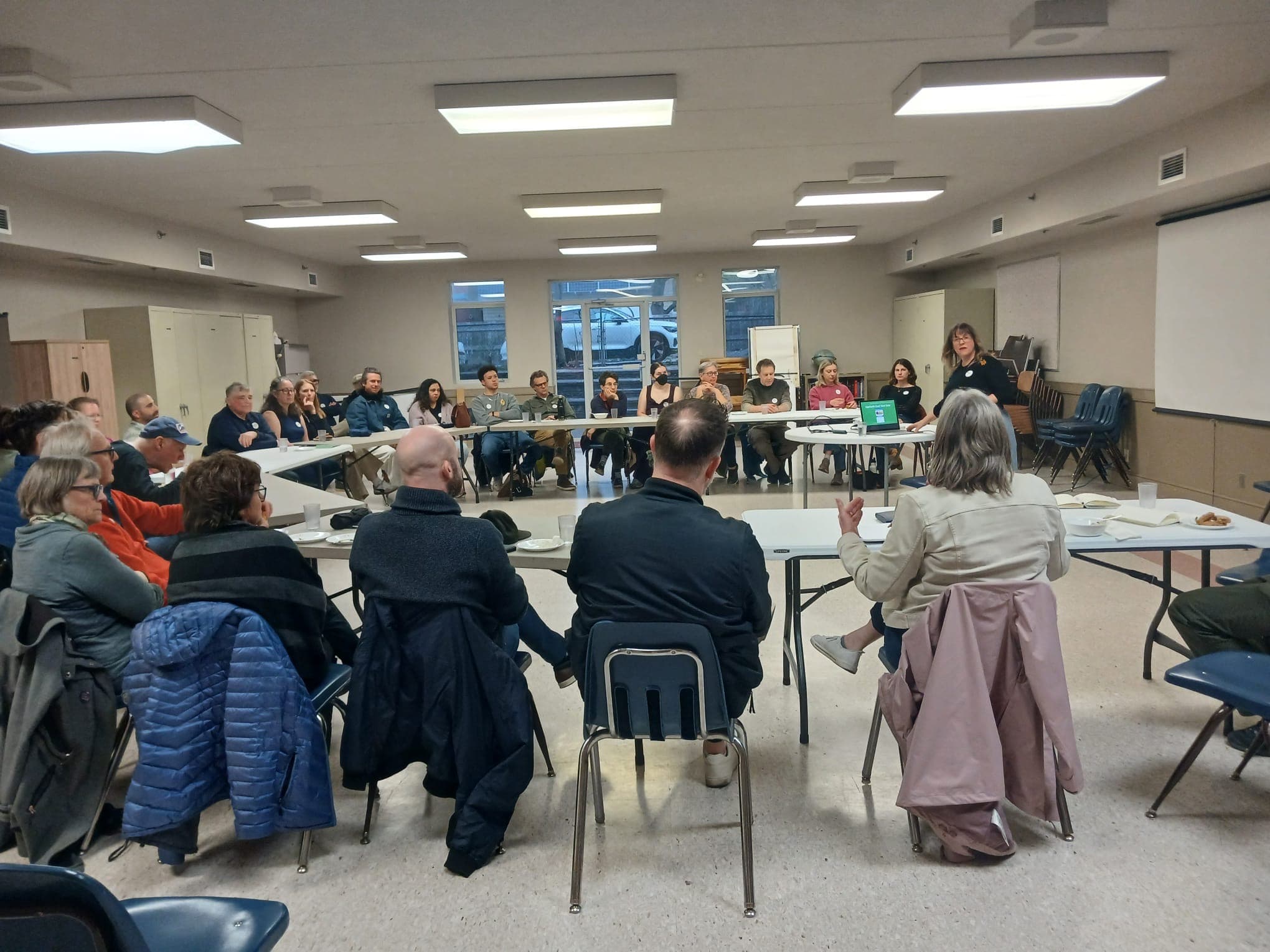 Packed community meeting with neighbours organizing for noise protections